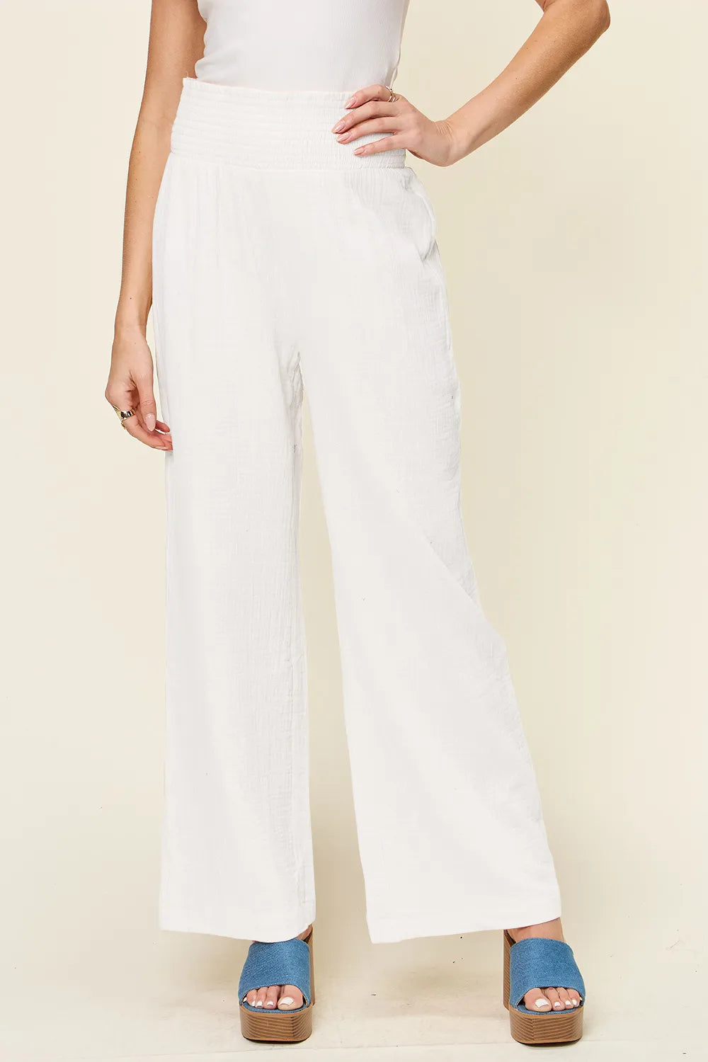 White textured wide-leg pants with smocked waistband, full-length side view