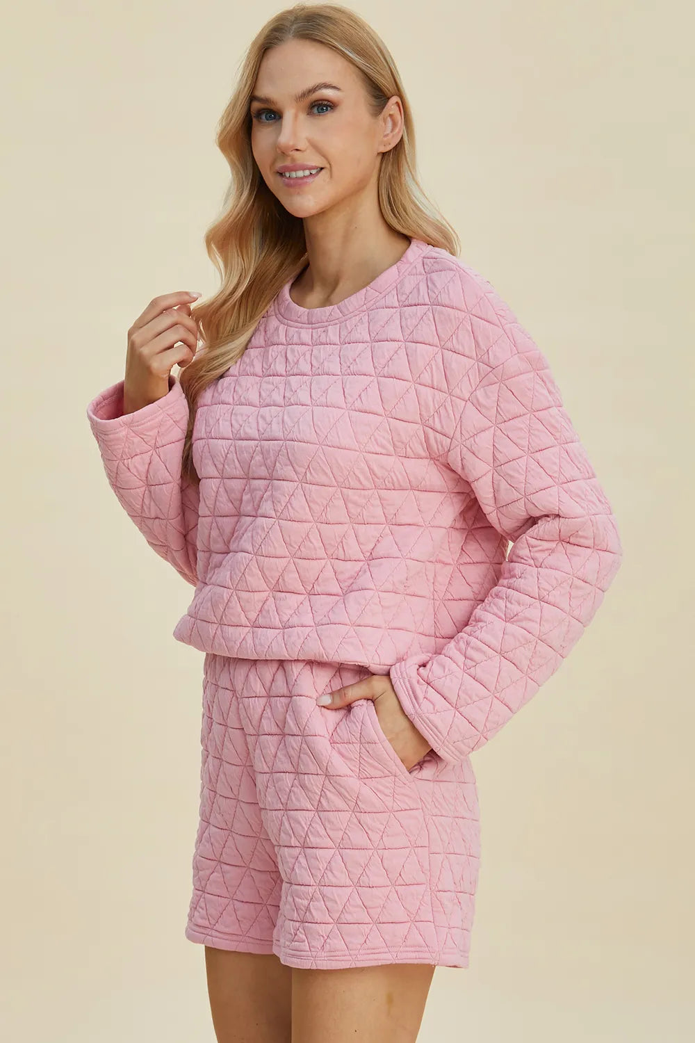 Pink quilted long-sleeve top and shorts set, round neck, hand-in-pocket detail.